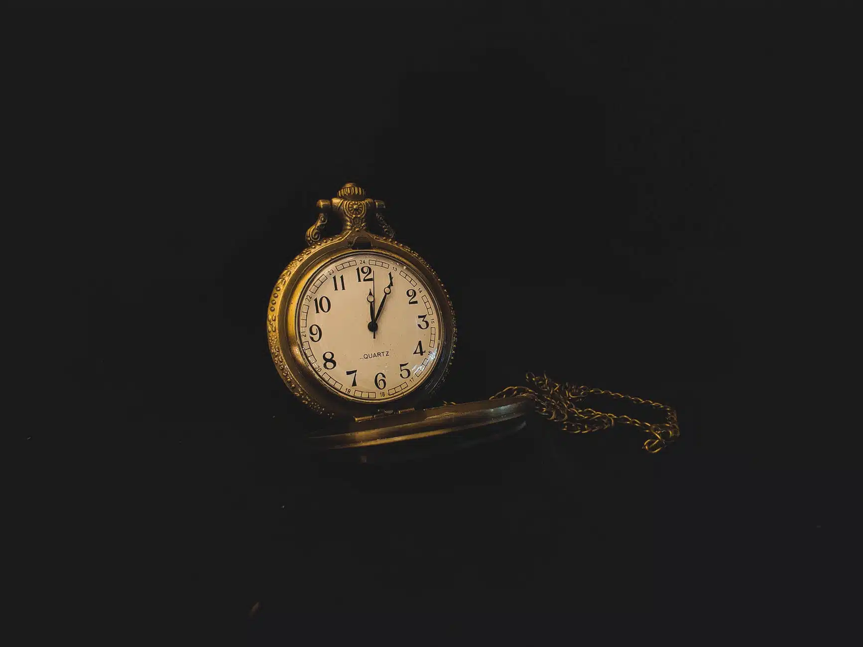 retro clock on chain on black background
