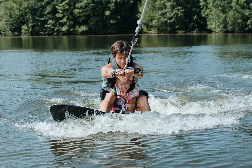 A father and daughter enjoying a thrilling wakesurfing experience on a sunny day.