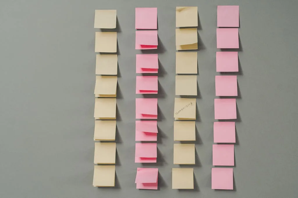 Rows of pink and yellow sticky notes on a gray background, ideal for planning concepts.